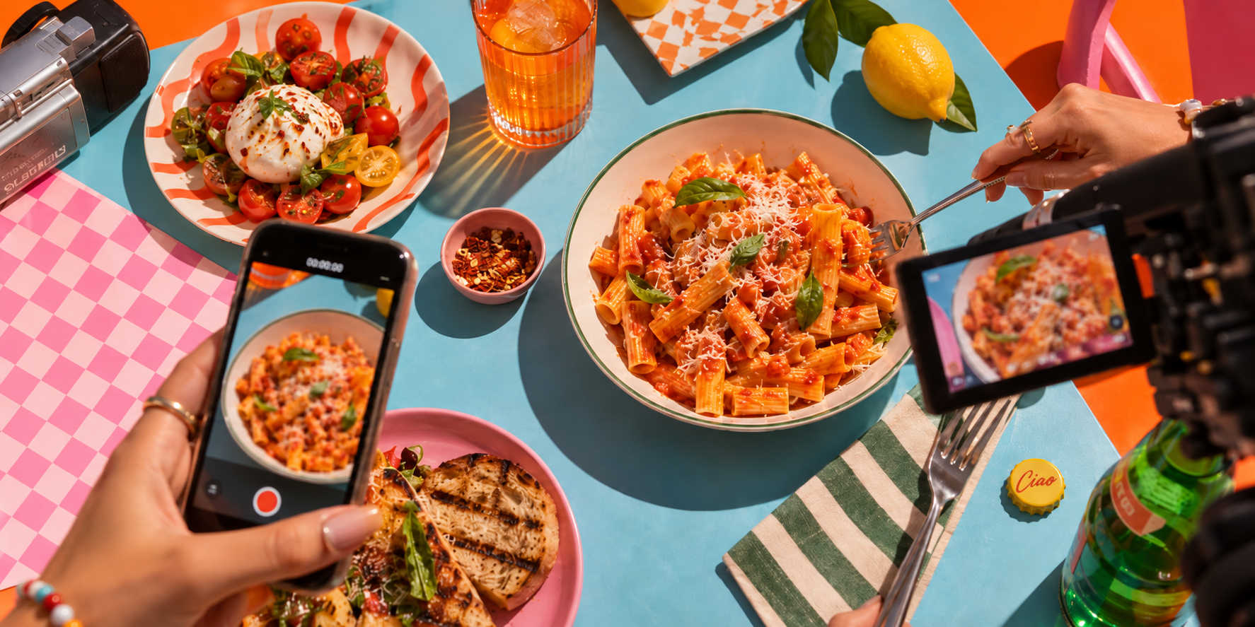 Set colorato di produzione food con pasta al pomodoro, smartphone e videocamera